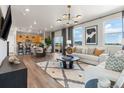 Bright, open living space with wood floors, large windows, and modern decor, seamlessly connected to the kitchen at 2121 Barnwood Dr, Brighton, CO 80601