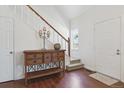 Inviting foyer featuring a hardwood floor, decorative table, staircase with white railings, and natural light at 4750 S Dudley St # 21, Littleton, CO 80123