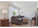 Comfortable living room featuring a large window, plush sofa, decorative rug, and a view of the backyard at 4750 S Dudley St # 21, Littleton, CO 80123