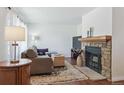 Cozy living room with a stone fireplace, plush sofa, decorative rug, and a view of the backyard at 4750 S Dudley St # 21, Littleton, CO 80123