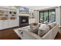 Bright living room with a fireplace, built-in shelves, and sliding glass doors to the outdoor patio at 1051 S York St, Denver, CO 80209