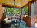 Cozy covered porch with brick columns, stylish seating, and a charming chandelier at 1051 S York St, Denver, CO 80209