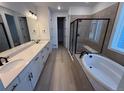 Modern bathroom featuring a double vanity, a soaking tub and a glass-enclosed shower at 1121 Joseph Pl, Erie, CO 80026