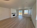 Bright living room featuring hardwood floors, a modern fireplace and sliding glass doors to the backyard at 1121 Joseph Pl, Erie, CO 80026