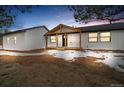 Charming home exterior with a welcoming front porch, black-framed windows, and fresh landscaping at 11840 Elkhorn Dr, Franktown, CO 80116