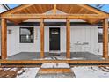 Inviting front porch with a charming wooden ceiling, black door, and table setting on a gray painted porch at 11840 Elkhorn Dr, Franktown, CO 80116