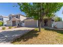 Traditional home featuring a manicured lawn, mature trees, and attached two-car garage at 5538 Espana Ct, Denver, CO 80249