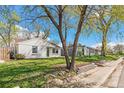 View of the home's exterior with a mature tree and landscaped yard and sidewalk at 4120 S Lincoln S St, Englewood, CO 80113