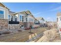 Back exterior view of townhomes featuring beautiful stone accents, neutral colors, and pristine landscaping at 14434 W 88Th Dr # B, Arvada, CO 80005