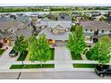 Aerial view of a residential neighborhood with a two-story home featuring a well-manicured lawn and mature trees at 4738 Colorado River Dr, Firestone, CO 80504