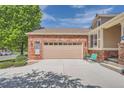 Brick home featuring a two-car garage and a well-maintained driveway at 20058 E Dartmouth Dr, Aurora, CO 80013