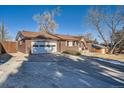 Attractive brick home with a large driveway and an attached two-car garage at 12771 W 6Th Pl, Lakewood, CO 80401