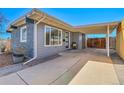 View of the charming home highlighting its well-kept exterior, stylish carport, and attractive landscaping at 5000 W Dakota Ave, Denver, CO 80219