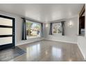 Bright living room featuring hardwood floors, natural light, and stylish wall sconces at 5000 W Dakota Ave, Denver, CO 80219