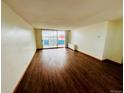 Spacious living room featuring hardwood floors, a neutral color palette, and a large sliding door to the balcony at 1155 N Ash St # 908, Denver, CO 80220