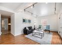 Bright living room featuring hardwood floors, a modern sofa, art, track lighting, and natural light at 960 N Sherman St # 2G, Denver, CO 80203