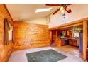 An open living space featuring wood walls, skylight, and vaulted ceiling flowing into the kitchen at 10893 Milliken Ave, Conifer, CO 80433
