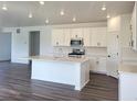 Modern kitchen with white cabinets, quartz countertops, a central island, and stainless steel appliances at 39743 Penn Rd, Elizabeth, CO 80107