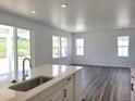 Bright and airy kitchen flowing to living area, featuring quartz countertops and wood floors at 39743 Penn Rd, Elizabeth, CO 80107