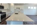 Bright kitchen island with quartz countertop, stainless steel appliances and stylish backsplash at 39743 Penn Rd, Elizabeth, CO 80107