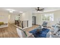 Spacious living room featuring wood floors, modern staircase, and a ceiling fan at 8622 W Warren Ln, Lakewood, CO 80227