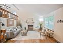 Comfortable living room with vaulted ceiling, wood floors, fireplace, and a second-story loft with wood railing at 5602 S Yank Ct, Littleton, CO 80127