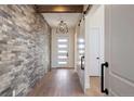 Inviting entryway featuring a brick accent wall, wood floors, and a front door with sidelights at 5741 Doc Bar Circle, Larkspur, CO 80118