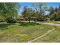 Well-maintained front yard with mature trees and a circular driveway at 4500 S Dasa Dr, Cherry Hills Village, CO 80111