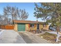 Charming brick home featuring a green garage door and contrasting wooden window shutters at 6431 W 77Th Pl, Arvada, CO 80003