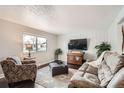 Cozy living room with neutral colors, plush furniture, and natural light from a bright window at 6431 W 77Th Pl, Arvada, CO 80003