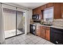 Functional kitchen with dark cabinetry, matching appliances, and access to a private outdoor space at 9338 W Utah Pl, Lakewood, CO 80232