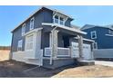 Attractive two-story home with gray siding, white accents, a covered porch with stone supports, and an attached two-car garage at 11024 Snowdon St, Parker, CO 80134