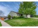 A cozy home with lush green lawn with mature trees on a sunny day at 5350 S Quail Way, Littleton, CO 80127