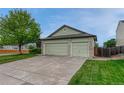 Exterior view showcasing a spacious three-car garage with a concrete driveway and green lawn at 5350 S Quail Way, Littleton, CO 80127