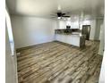 Open-concept living room with wood-look floors, white walls, new cabinets and countertops at 16800 E Bails Pl, Aurora, CO 80017