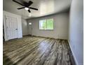 Spacious living area featuring wood-look flooring, ceiling fan and a view of the outdoor landscaping at 16800 E Bails Pl, Aurora, CO 80017