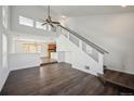 Open-concept living area featuring hardwood floors, high ceilings, and modern staircase at 5202 Cathay St, Denver, CO 80249