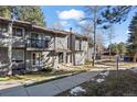 A townhouse with vertical wood siding has a small balcony and a covered front entryway at 2308 Hearth Dr # 28, Evergreen, CO 80439