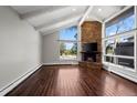 Living room with a stone fireplace, large windows, hardwood floors, and vaulted ceiling at 2308 Hearth Dr # 28, Evergreen, CO 80439