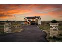 Elegant two-story house with stone columns, asphalt drive and an American flag at 8700 Lost Lake Dr, Franktown, CO 80116