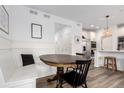 Cozy dining nook with a wooden table, built-in bench seating, and stylish decor and adjacent kitchen at 509 High Point Dr, Longmont, CO 80504