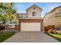 Two-story home with a two-car garage, driveway, landscaped yard, and beautiful curb appeal at 14035 Touchstone St, Parker, CO 80134
