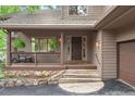 Inviting home entrance featuring a cozy covered porch and stone steps leading to the front door at 29962 Troutdale Ridge Rd, Evergreen, CO 80439