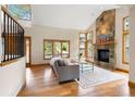 Spacious living room boasts a stone fireplace, natural light, and beautiful hardwood floors at 29962 Troutdale Ridge Rd, Evergreen, CO 80439