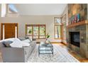 Bright living room with large windows, a stone fireplace, and hardwood floors for a cozy atmosphere at 29962 Troutdale Ridge Rd, Evergreen, CO 80439