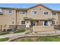 Charming exterior view of a tan townhome with a lovely front porch and well-maintained landscaping at 1601 Great Western Dr # D3, Longmont, CO 80501
