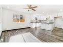 Modern kitchen with white cabinets, island, and gray flooring at 655 S Osceola St, Denver, CO 80219