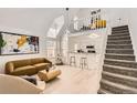 Bright living room featuring stairs leading to a loft, stylish decor, and vaulted ceilings at 14129 E Dickinson Dr # D, Aurora, CO 80014