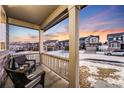 Covered porch with wicker chairs, overlooking a residential street at 2633 Garganey Dr, Castle Rock, CO 80104