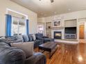 Comfortable living room showcases a stone fireplace, plush seating, and natural light from a large window at 5175 Quari St, Denver, CO 80239